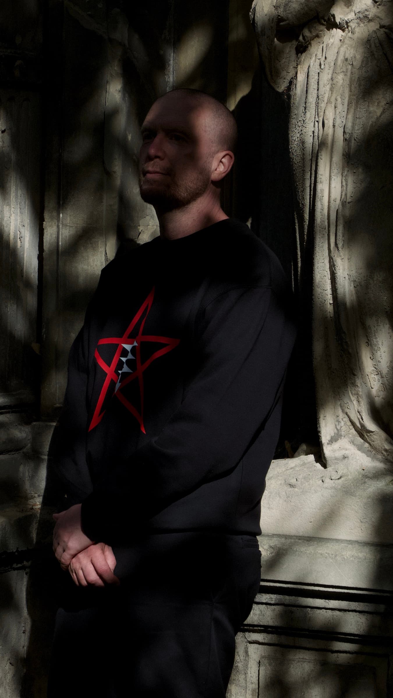 Side view of another model wearing the LVX sweatshirt in dappled light